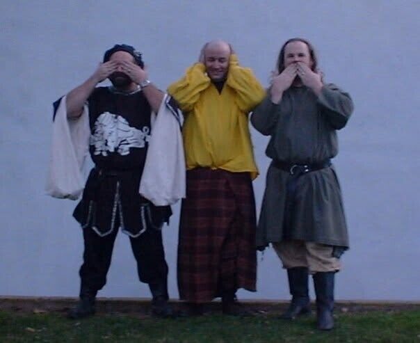 Three men in medieval dress posing as see no evil, hear no evil, speak no evil